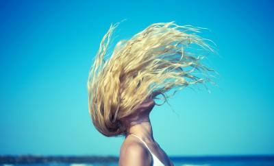 Girl on beach flips her hair