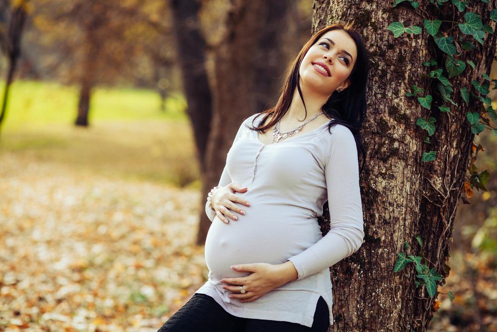 Woman leaning against tree