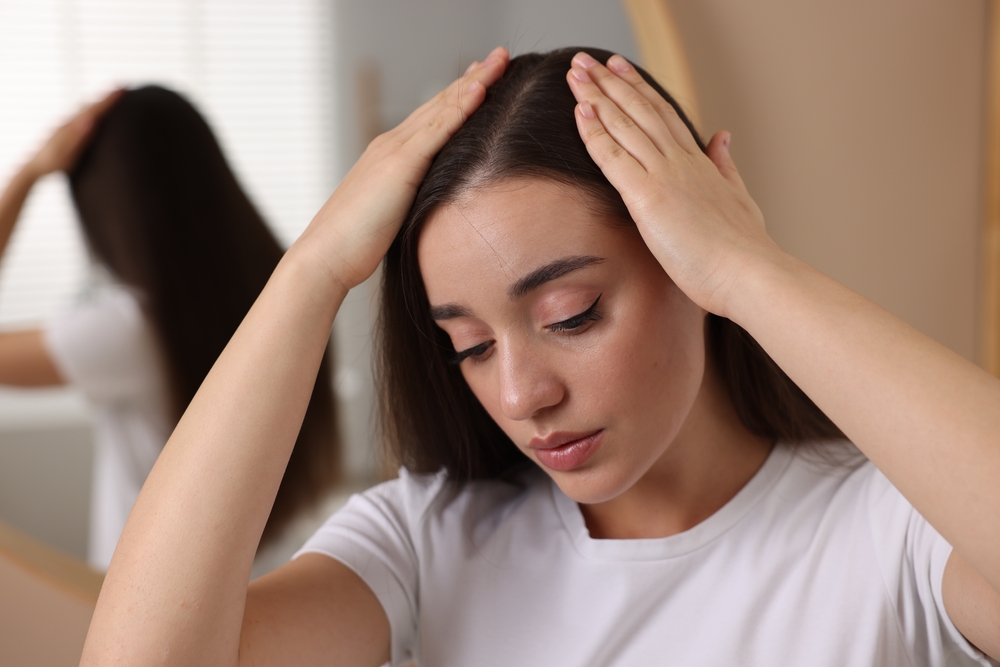Woman touching her scalp