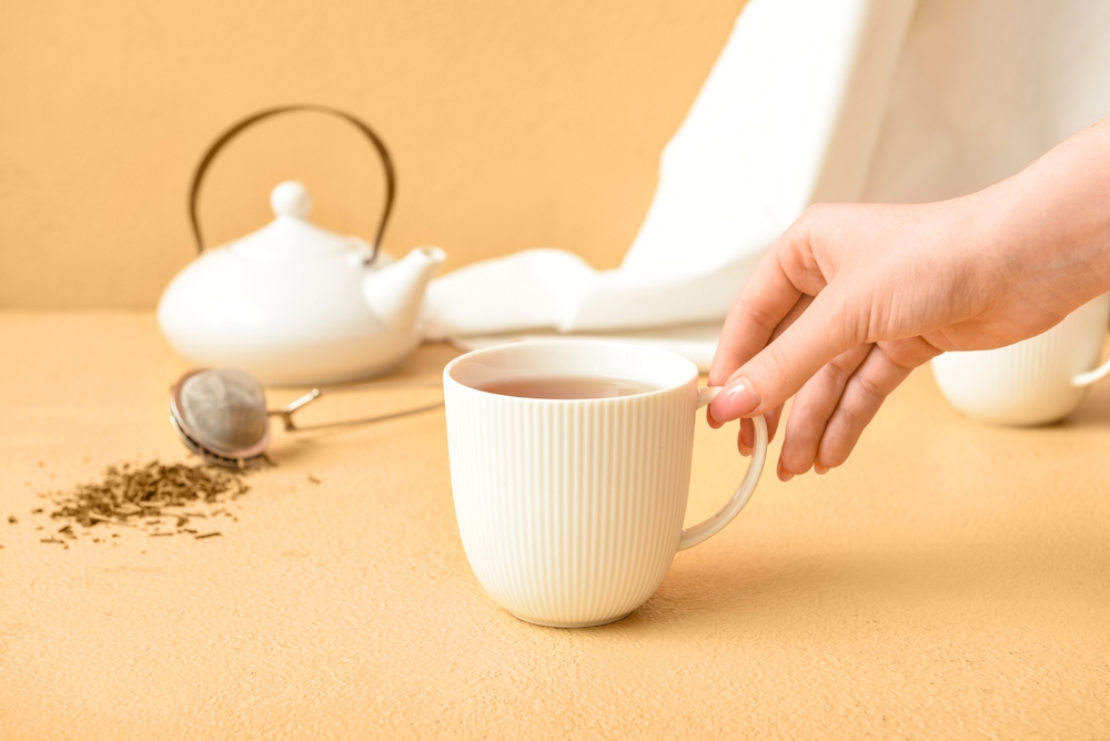Woman holding cup of hojicha instead of matcha