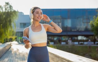 Woman practicing walking yoga while listening to music through headphones