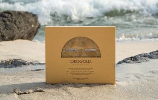 Box of Orogold face masks on beach